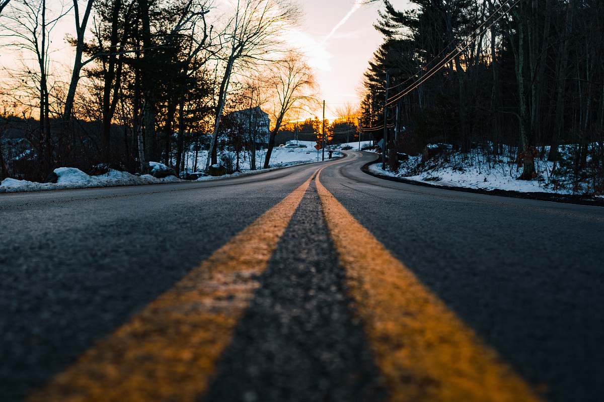 road photography of concrete road with snow and tree surround it pelham